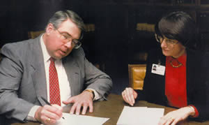 Dr. Carl Booberg (Director of the ALAV in 1991) signing over the ALAV Collection to Linda Watson