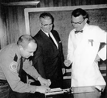 William Lamm, Hospital Director of Security, gets John Stacy's fingerprints while Dean Crispell observes the new ID card process